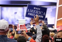 A covention delegate holds a "Make America First Again" sign at the Republican National Convention, July 20, 2016. (A. Shaker/VOA)