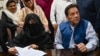 FILE - Pakistani former Prime Minister Imran Khan, right, and his wife, Bushra Bibi, sign surety bonds for bail in various cases at a registrar's office in Lahore, Pakistan, on July 17, 2023.