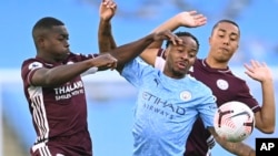 Leicester's Nampalys Mendy, left vies for the ball with Manchester City's Raheem Sterling, center and Leicester's Youri Tielemans during the English Premier League soccer match between Manchester City and Leicester City at the Etihad stadium in Manchester