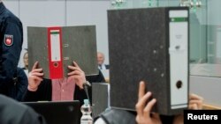 متهمان صورتهای خود را در دادگاه پوشانده اند. 