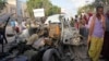 Somalis gather near the wreckage of a car used in an attack outside a beachfront restaurant in Mogadishu, Somalia, Aug. 26, 2016. Experts call for a unified counterterrorism effort. 
