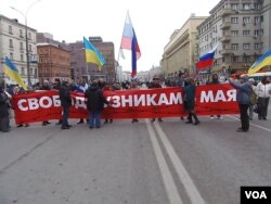 2014年3月在莫斯科举行的一场反对侵略乌克兰的抗议集会上，示威者手举乌克兰和俄罗斯国旗，呼吁释放政治犯。