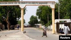Wata mata na ketare titin mota a garin Bulumkutu, bayan da sojoji suka kafa dokar hana fita waje a Maiduguri dake Jihar Borno. Mayu 19, 2013.