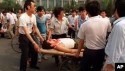 1989年6月4日，在解放军士兵向人群开火后不久，当地居民将伤员抬上了一辆人力平板车。 