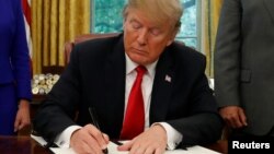 도널드 트럼프 미국 대통령이 20일 '아동 격리 수용' 철회 행정명령서에 사인하고 있다. 