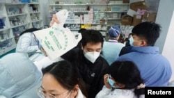 人们在杭州一家药店排队购买新冠病毒抗原检测试剂盒。（2022年12月19日）