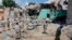 Somali soldiers look at the destroyed houses amidst the wreckage of a car bomb blast in Mogadishu, Somalia, May 17, 2017. Three bomb disposal experts were killed as they were trying to dismantle the car laden with explosives, according to police.