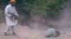 This still image taken from undated video footage depicts a man Afghan officials identified as a member of the Taliban firing his rifle at a woman accused of adultery during her execution in a village outside Kabul, Afghanistan.