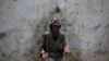 A man cools off from a public tap after filling bottles during intense hot weather in Karachi, Pakistan, June 23, 2015.