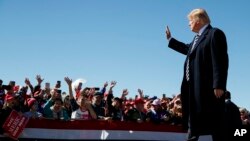 Presiden Donald Trump melambaikan tangan saat turun dari panggung di Bandara Elko, setelah berpidato untuk kampanye, Elko, Nevada, 20 Oktober 2018.