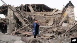 ເຈົາຂອງເຮືອນ, ນາງ ລີດາ ຊາກສຢານ, ຢືນຢູ່ໃກ້ກັບເຮືອນທີ່ຖືກທຳລາຍຂອງລາວ ໂດຍການຍິງຖະຫຼົ່ມຂອງປືນໃຫຍ່ ອາເຈີບາຍຈານ, ໃນລະຫວ່າງຄວາມຂັດແຍ້ງທາງທະຫານ ໃນເມືອງ ສເຕປານາເກີດ, ເຂດແບ່ງແຍກ ນາກໍໂນ-ຄາຣາບັກ, 17 ຕຸລາ, 2020.