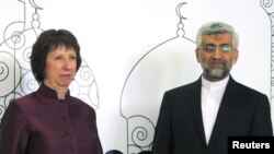 Catherine Ashton (kiri) dan ketua perunding Iran, Saeed Jalili berpose untuk media sebelum pembicaraan di Baghdad (23/5). Kedua pihak sepakat untuk melanjutkan pembicaraan di Moskow.