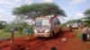 Kenyan security forces and others gather around the scene on an attack on a bus about 50 kilometers outside the town of Mandera, near the Somali border in northeastern Kenya, Nov. 22, 2014.