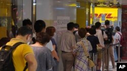 People queue up outside the DHL Express store in Hong Kong, Monday, June 1, 2020. Throngs of people lined up at DHL courier outlets across the city on Monday, many to send documents to the U.K. to apply for or renew what is known as a British…