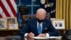 FILE - President Joe Biden signs an executive order, in the Oval Office of the White House, in Washington, Feb. 2, 2021.