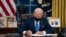 FILE - President Joe Biden signs an executive order, in the Oval Office of the White House, in Washington, Feb. 2, 2021.