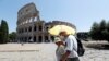 People walk past the Colosseum, amid the outbreak of the coronavirus disease (COVID-19), in Rome, Italy, July 31, 2020. R