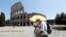People walk past the Colosseum, amid the outbreak of the coronavirus disease (COVID-19), in Rome, Italy, July 31, 2020. R