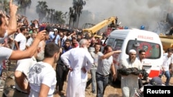 Seorang Muslim Sunni berlari membawa potongan tubuh yang terbakar sesudah terjadi ledakan bom di luar masjid di Tripoli, Lebanon (23/8) 