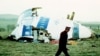 Un policier passe devant l'épave du vol 103 de la Pan Am dans un champ près de la ville de Lockerbie, en Écosse, où il se trouvait après qu'une bombe à bord ait explosé le 21 décembre 1988. (Archives)