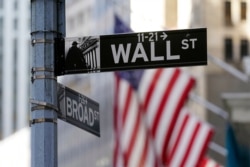 FILE - Flags adorn the facade of the New York Stock Exchange, in New York City, June 16, 2021, as traders wait for the latest decision on interest rates from the U.S. Federal Reserve.