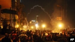 这张于2013年1月26日拍摄的图片显示，在开罗市中心沿着尼罗河岸的一家国际大饭店的前面，安全部队使用催泪瓦斯回击向他们扔石头的示威者