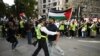Petugas kepolisian menahan seorang aktivis pro-Palestina yang mencoba mendekat ke arah demonstran pro-Israel dalam aksi unjuk rasa untuk Palestina di London, pada 5 Oktober 2024. (Foto: AFP/Justin Tallis)
