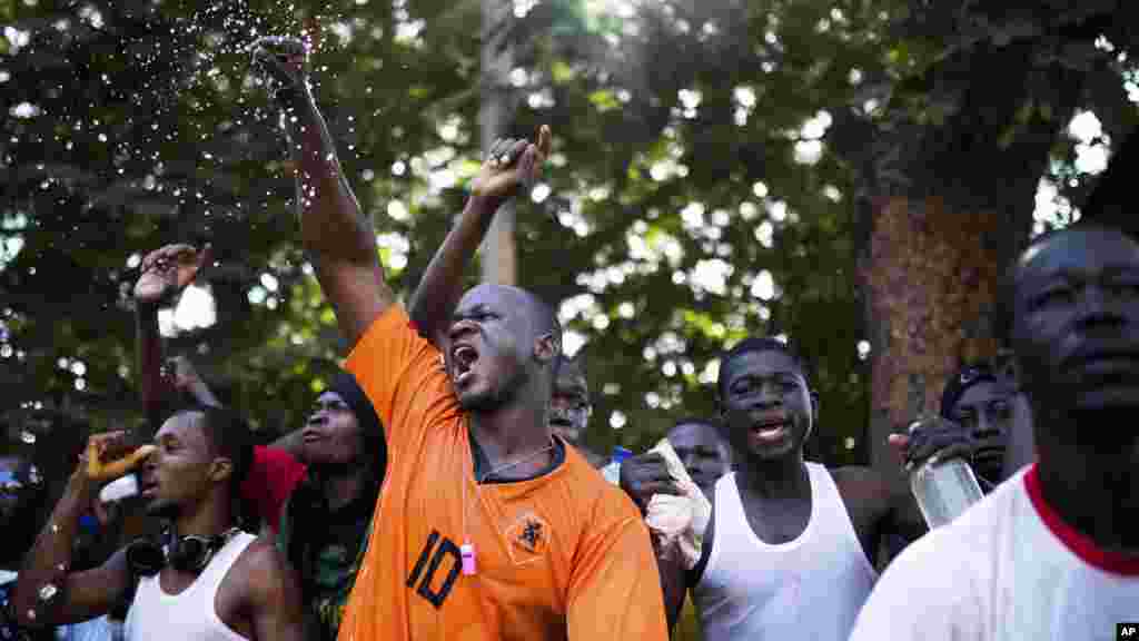 Sur cette photo prise le jeudi 30 octobre 2014, les manifestants vocifèrent alors qu&rsquo;ils viennent de saccager et brûler un bâtiment du Parlement au Burkina Faso. Des scènes de liesse et des pillages ont eu lieu au Burkina Faso après que le président Blaise Compaoré a annoncé vendredi 31 octobre 2014 qu&rsquo;il quittait le pouvoir. Il a régné 27 années. (AP Photo / Theo Renaut) 