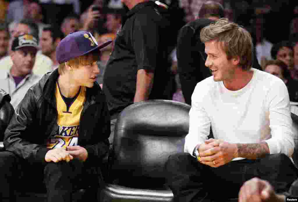 Justin Bieber berbincang dengan David Beckham selama pertandingan NBA antara Los Angeles Lakers danHouston Rockets di Los Angeles, California, 20 Oktober 2010. (Reuters/Lucy Nicholson)