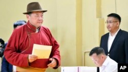 Speaker of Parliament and Mongolian People's Party presidential candidate Miyegombo Enkhbold, left, casts his vote at a polling station at a school in Ulaanbaatar, Mongolia, June 26, 2017. 