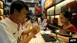 A man looks at a gold product at a Bao Tin Minh Chau gold shop in Hanoi on June 21, 2013. 