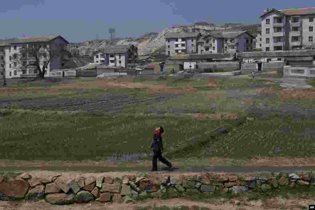 2013年4月24日，一名朝鲜男孩走在村口的公路上。这里位于开城以南。朝鲜开城在分隔朝鲜半岛南北方的非军事区以北，有南北方联合开发的工业园区，目前被朝鲜关闭。