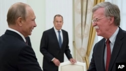 博尔顿（右）2018年6月27日在莫斯科会见普京与拉夫罗夫（美联社）