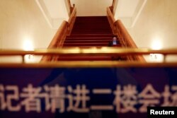 在全国人大会议投票表决通过修宪案后，一名记者坐在北京人大会堂的台阶上工作。（2018年3月11日）