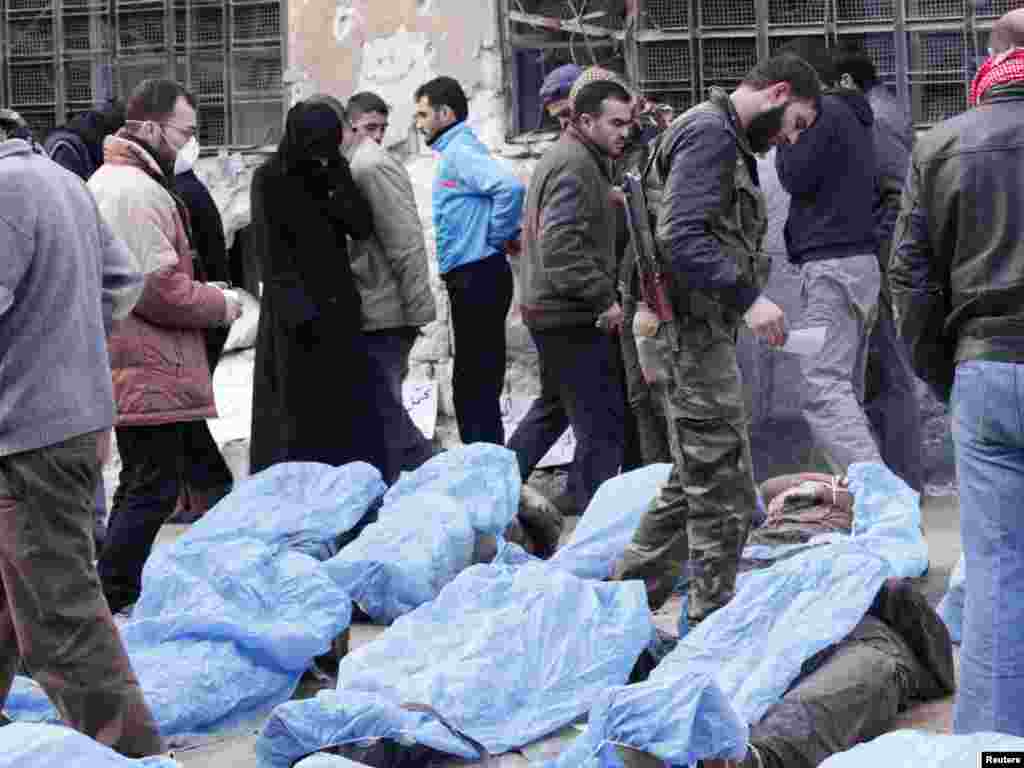叙利亚自由军的战士和当地居民1月29日试图在一个用作战地医院的学校里识别从阿勒颇一条河流里找到的尸体