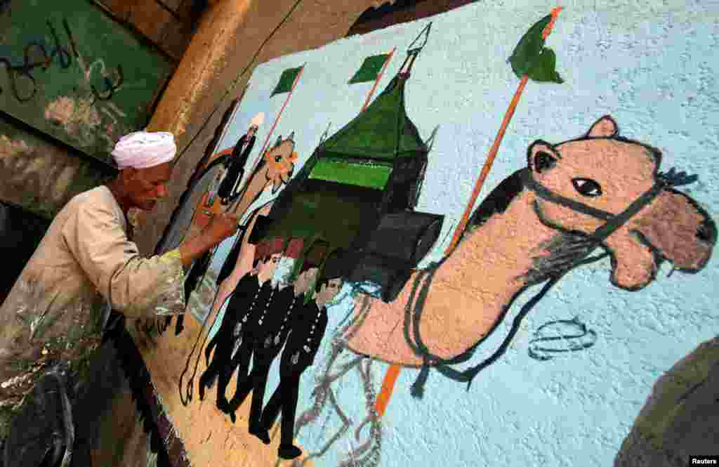 Mchoraji Eid Al Salwaawi akimaliza kuchora picha ya Kaaba na maeneo mengine ya ibada ya Hijja, Mecca, Cairo, Misri, Julai 17, 2019.