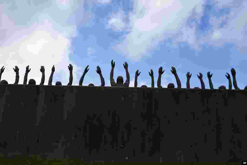 នេះ​ជារូប​ចម្លាក់សំរិទ្ធ​ហៅ​ថា &laquo;លើកឡើង&raquo; ដែលជា​ផ្នែក​មួយ​នៅ​ក្នុង​ការតាំង​បង្ហាញ​នៅ​ឯទី​តាំង​រំឮកវិញ្ញាណក្ខន្ធ​ជាតិ​សម្រាប់​សន្តិភាព​និង​យុត្តិធម៌​ដែល​ជា ទីតាំង​ថ្មី​ដើម្បី​រំឮក​ដល់​ជនរងគ្រោះ​រាប់ពាន់​នាក់នៅ​ក្នុង​ការ​សម្លាប់​ពូជសាសន៍​ក្នុង​ទីក្រុង​ Montgomery រដ្ឋ Alabama កាលពី​ថ្ងៃទី​២៣ មេសា ២០១៨។