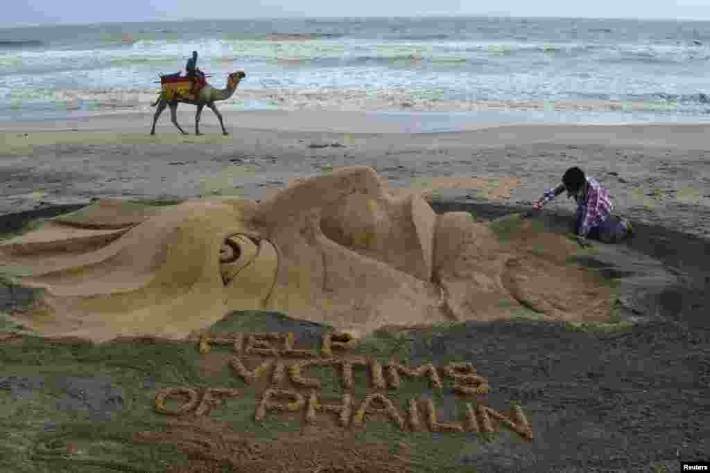 Artis pasir India, Sudarshan Pattnaik membuat patung tentang Topan Phailin yang melanda Puri di negara bagian Odisha, India timur.