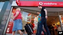 2014年6月6日星期五人们走过伦敦沃达丰商店