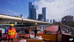 资料照片：工人在上海某地整修一座高架人行天桥。(2024年10月9日)