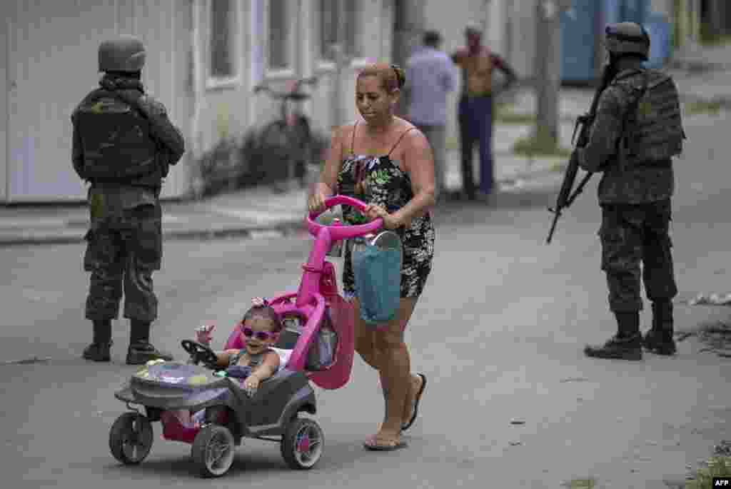 Soldiers of Brazil's Armed Forces, backed by armored vehicles, aircraft and heavy engineering equipment (not shown), take part in an operation in the violence-plagued favela of Vila Kennedy, in Rio de Janeiro.