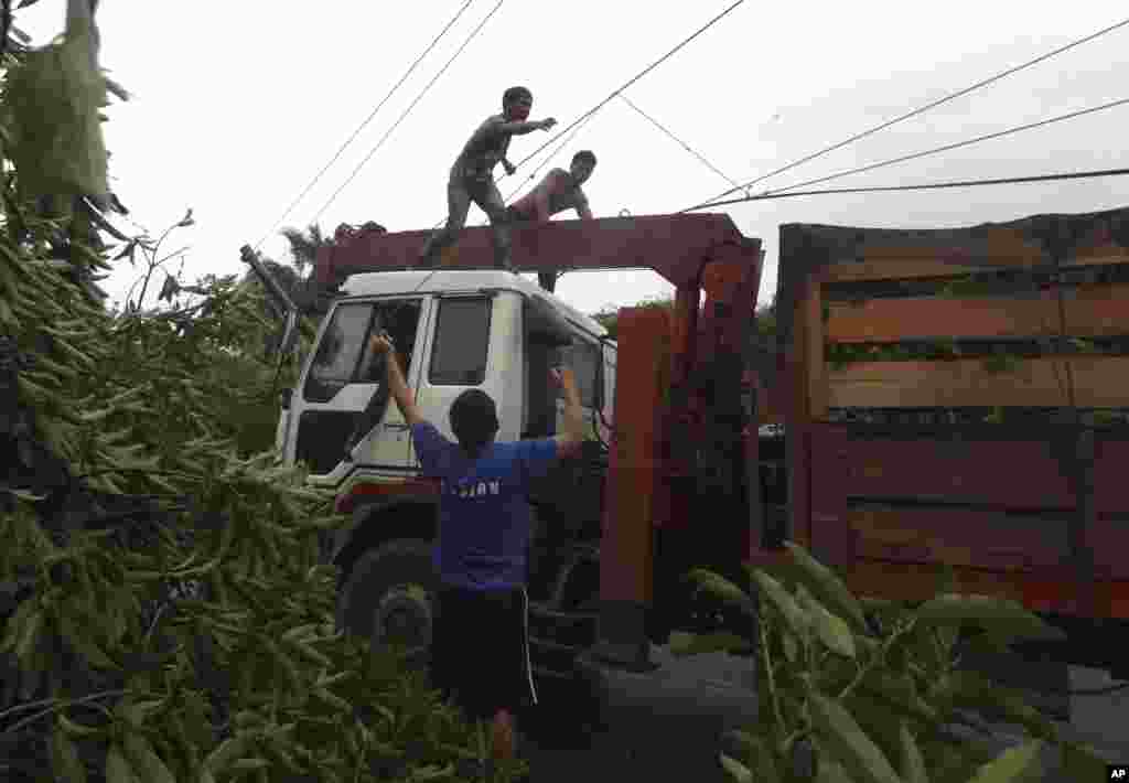 Workers clear a highway of toppled trees after Typhoon Bopha made landfall in Compostela Valley, Philippines, December 4, 2012.