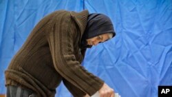 A voter casts a ballot in Targusoru Nou, Romania, Dec. 11, 2016. Romanians began voting Sunday in a parliamentary election a year after a massive anti-corruption drive forced the last Socialist prime minister from power. 