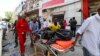 Somali emergency services evacuate a body from a car bombing at a shopping mall in Mogadishu, Somalia, Feb. 4, 2019. Al-Shabab claimed responsibility for the attack.