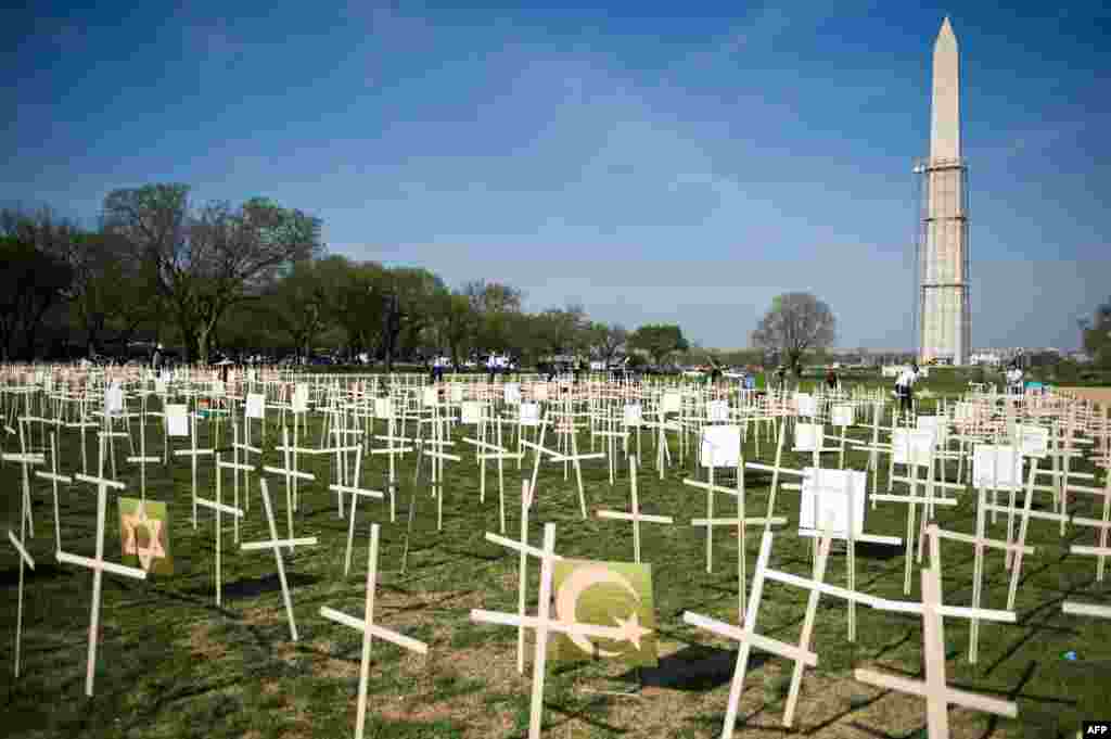 Ratusan kayu salib ditempatkan di dekat Monumen Washington di Washington DC. Salib-salib ini melambangkan jumlah korban tewas akibat kekerasan senjata api di AS sejak insiden penembakan di sebuah Sekolah Dasar di kota Newtown, Connecticut Desember 2012 lalu.