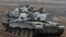 FILE - British troops atop tanks salute as they take part in joint military exercises with Polish troops in Swietoszow, Poland, Nov. 21, 2014.