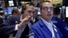 Trader Gregory Rowe, left, talks to specialist Neil Gallagher as they work on the floor of the New York Stock Exchange, Aug. 28, 2015.