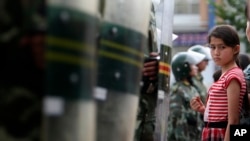 资料照：乌鲁木齐的一个维吾尔族小女孩被中国武警挡住去路。