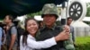 A pro-government demonstrator embraces a Thai soldier during a cleanup operation at a pro-government demonstration site on the outskirts of Bangkok, Thailand, May 23, 2014. 