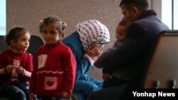 18일 시리아에서 한국에 도착한 난민이라고 밝힌 여성이 남편으로 추정되는 남성, 아이 셋과 함께 영종도 인천국제공항 내 입국심사장 인근에 앉아 대기하던 중 눈물을 흘리고 있다.